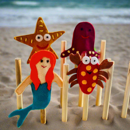 Set of four hand-embroidered ocean finger puppets including a mermaid, crab, octopus, and sea star, designed for imaginative play.
